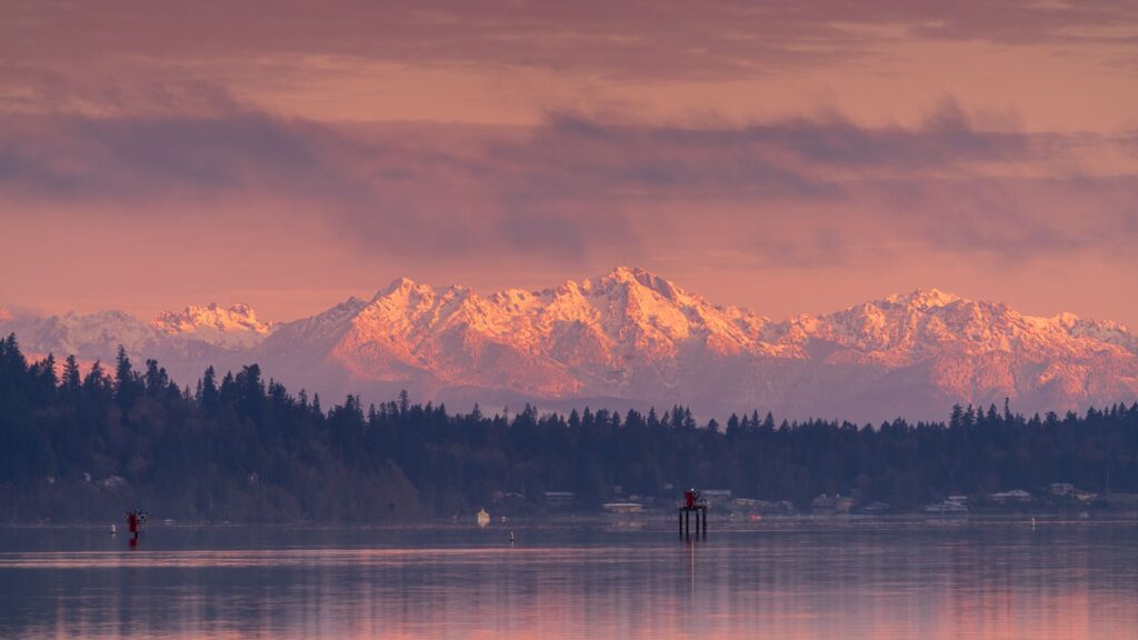 a lake with view of mountain ranges during sunset